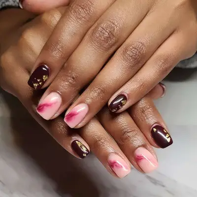 Model with pink and brown nails with gold and fuchsia details