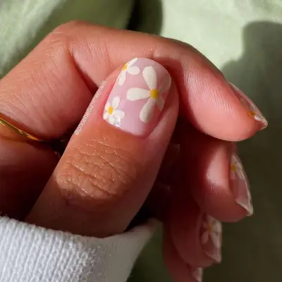 Model with a bare nail base and large white daisies