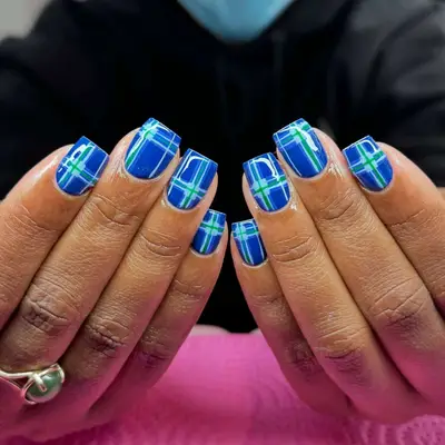 Model with blue and green plaid nails