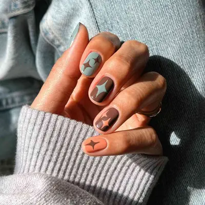 model with blue, brown, and orange nails with star design
