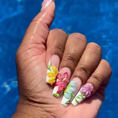 french nails with 3d flowers in shades of yellow, pink, blue, purple