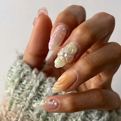 nails with 3d flowers, rhinestones, and pink accents