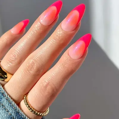 Manicure with shimmery peach and orange base and hot pink French tips