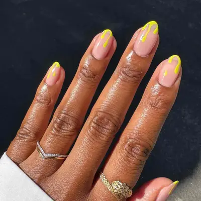 Manicure with neutral base and yellow drip French tips