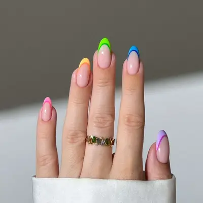 Close-up of manicure with rainbow two-tone French tips