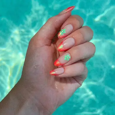 Manicure with coral shimmer French tips and green flower designs