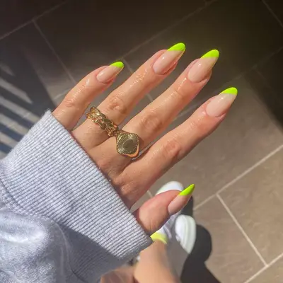 Manicure with neutral base and diagonal neon yellow French tips