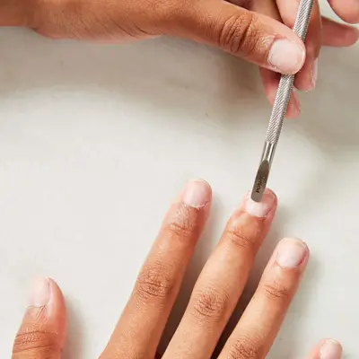 Woman scraping her fingernail