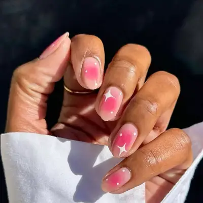 Natural nails with pink airbrush aura design and white stars