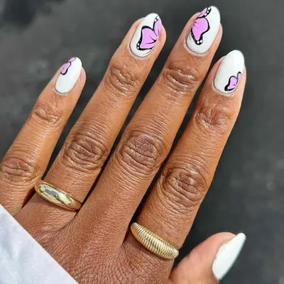 A white manicure with pink butterflies