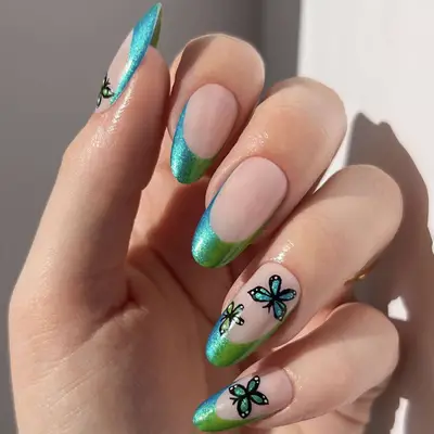 A french manicure with blue and green butterflies