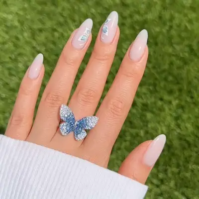 Almond-shaped nails with milky base and butterfly nail art