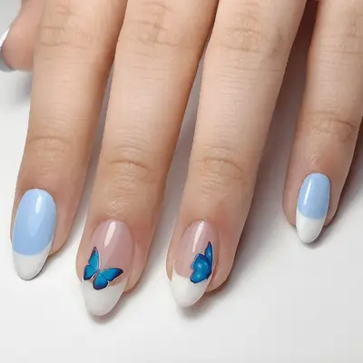 Manicure with neutral base and confetti tips featuring colorful and butterfly details