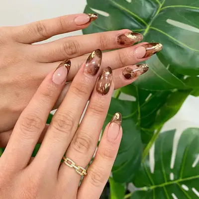 Brown and metallic tortoiseshell French manicure with gold accents