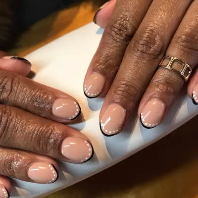 French manicure with a thin black line and white dots