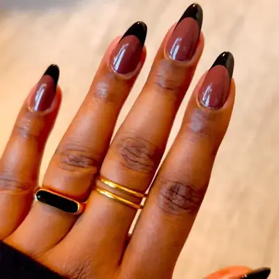 Black French manicure with gold star detailing