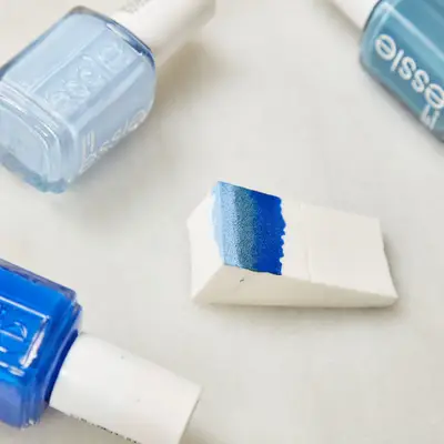 A wedge sponge painted with three shades of blue polish