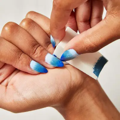 Woman blots ombré polish onto her nails