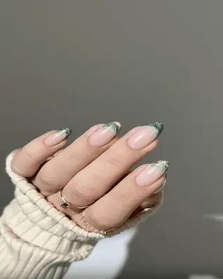 Manicure with green French tips and white swirl nail art 