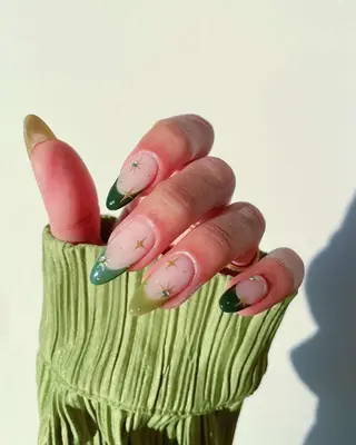Green French manicure with gold chrome stars and rhinestones