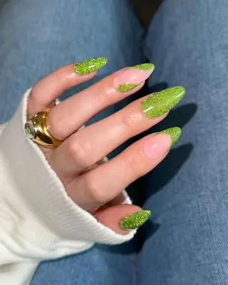 Long almond nails with green glitter polish in solid, wave, and French tip designs