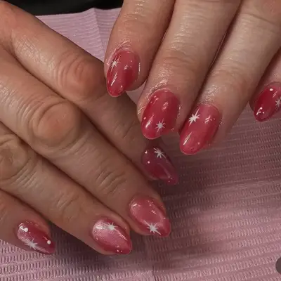Close up of short nails with glitter blue accent nails, pinstripe prints, and stars