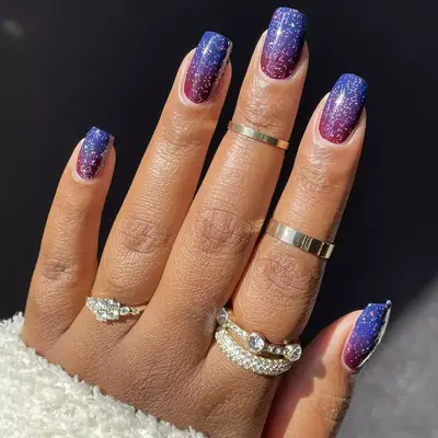 Square-shaped nails with red and blue gradient and glittery overlay