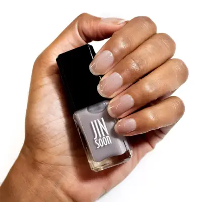 model holding sheer gray nail polish