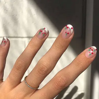 Hand with short round French Manicure with mini cherry design