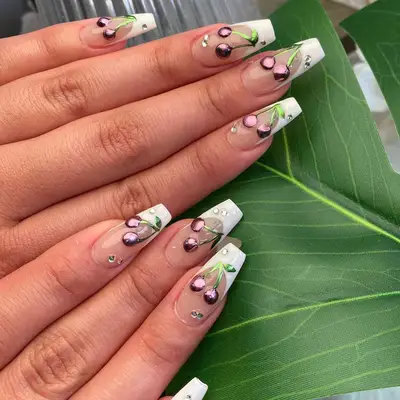 Hand with long square nails with a French manicure and purple chrome cherries.