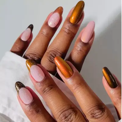 model with duotone orange, brown, and amber chrome nails