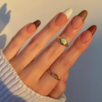 model with bare nails and brown, taupe, and cream French tips