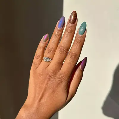 model with iridescent pink, purple, brown, green, and muave nails