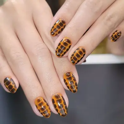 model with orange nails with brown snake print