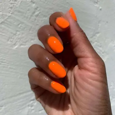 A highlighter orange manicure close up