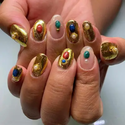 Close up of a 24 carat gold mani with stone details