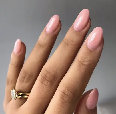 A soft pink polish on medium length oval nails