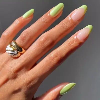 Sculpted gel nails in lime green with French tip accents