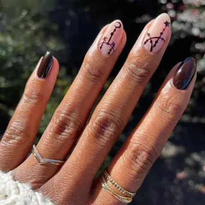 Deep red-brown nails with coven nail art.