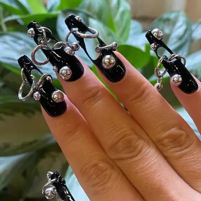 Black nails with holes and piercings.