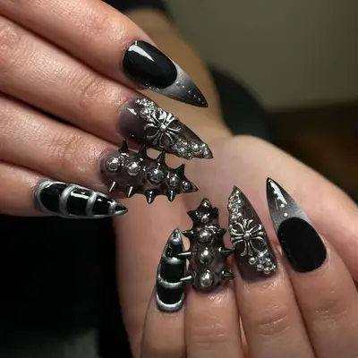 Black and gray nails with studs and embellishments.