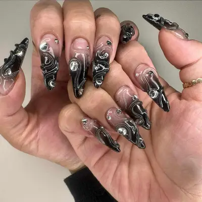Jelly black and light gray base manicure with 3-D swirling art and studs.