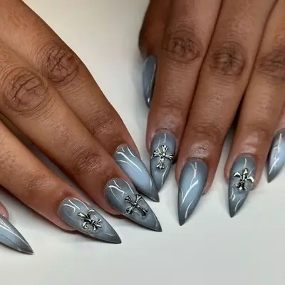 Extra glossy gray halo nails with embellishments on four fingers of fleur de lis and crosses.