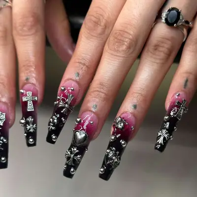 Black to maroon ombre base manicure with lots of silver gems with crosses, dots, hearts, bugs, and other designs.