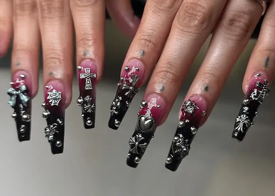 Black to maroon ombre base manicure with lots of silver gems with crosses, dots, hearts, bugs, and other designs.