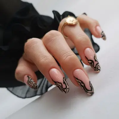 A neutral manicure with squiggly black tips
