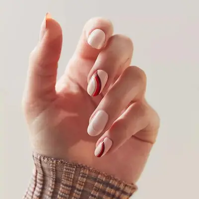 Manicure with neutral base and red and brown wavy design