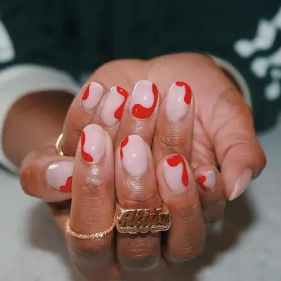 Milky manicure with splotchy red nail design
