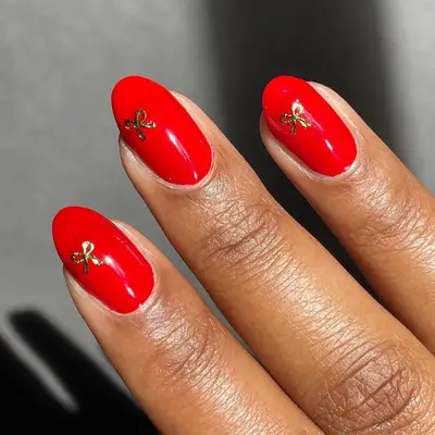 Red manicure with gold bow designs