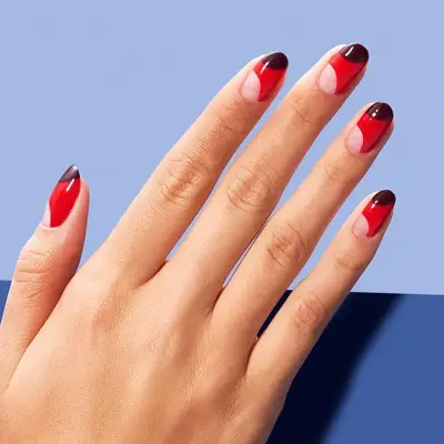 Red nails with negative space diagonal half moon at cuticle and dark half moon at tip